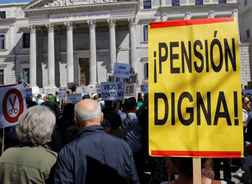 Manifestación por pensiones justas frente al Congreso de los Diputados en Madrid, con un cartel grande que dice '¡PENSIÓN DIGNA!' y otros con el lema 'VIEJO SÍ, TONTO NO'