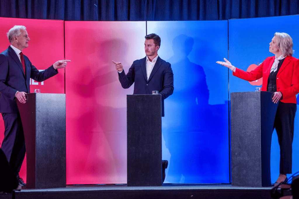 Tres políticos durante un debate público señalándose mutuamente, representando la estrategia política del "y tú más" y el cruce constante de acusaciones entre partidos en España.