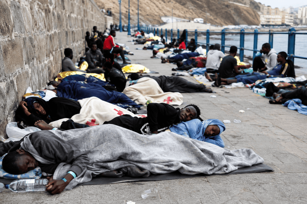 Inmigrantes duermen en mantas y colchones improvisados en un paseo marítimo de Ceuta