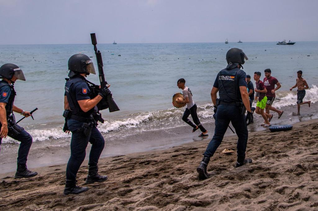 Agentes de la Policía Nacional intervienen en una playa de Ceuta ante la llegada de inmigrantes por mar